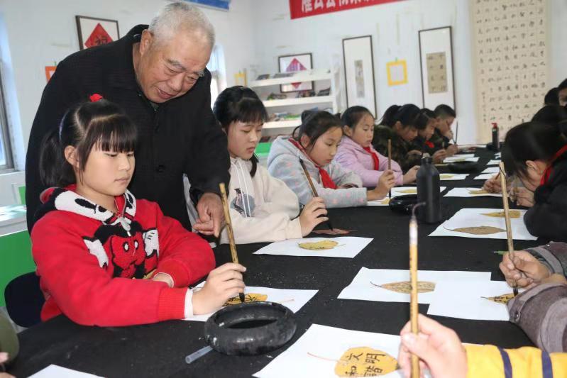 杨集镇校外辅导站“五老”辅导员辅导孩子们写字.jpg
